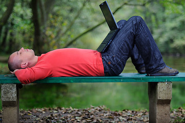 Image showing young businessman outdoor working on laptop