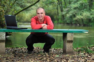 Image showing young businessman working on laptop outdoor