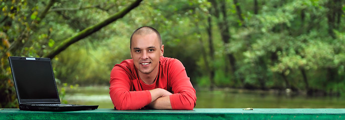 Image showing young businessman outdoor working on laptop