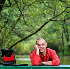 Image showing young businessman outdoor working on laptop
