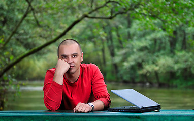 Image showing young businessman outdoor working on laptop