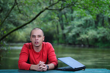 Image showing young businessman outdoor working on laptop