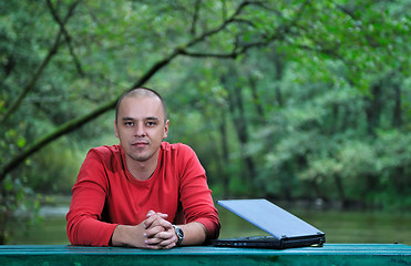 Image showing young businessman outdoor working on laptop