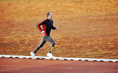 Image showing adult man running on athletics track