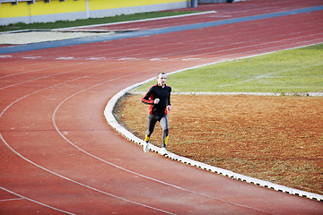 Image showing adult man running on athletics track