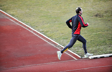 Image showing adult man running on athletics track