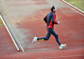 Image showing adult man running on athletics track