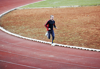 Image showing adult man running on athletics track
