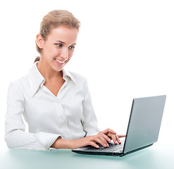 Image showing friendly administrative assistant at the desk with a laptop