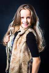 Image showing  girl with fair long hair in fur vest on dark background