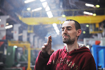 Image showing industry worker smoke cigarette