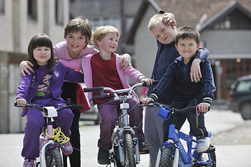 Image showing happy childrens group learning to drive bicycle