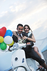 Image showing just married couple on the beach ride white scooter