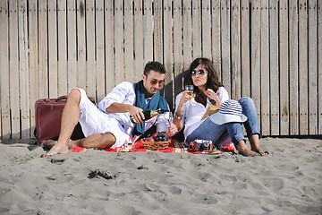 Image showing young couple enjoying  picnic on the beach