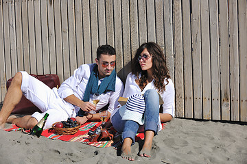 Image showing young couple enjoying  picnic on the beach