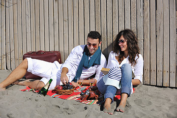 Image showing young couple enjoying  picnic on the beach