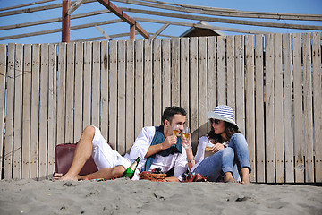 Image showing young couple enjoying  picnic on the beach