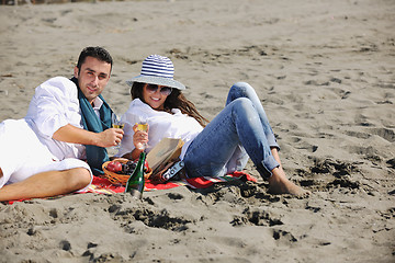 Image showing young couple enjoying  picnic on the beach