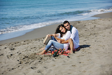 Image showing young couple enjoying  picnic on the beach