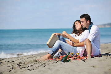 Image showing young couple enjoying  picnic on the beach