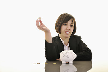 Image showing business woman putting coins money in piggy bank