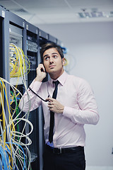 Image showing it engeneer talking by phone at network room