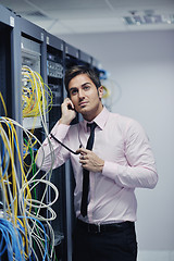 Image showing it engeneer talking by phone at network room