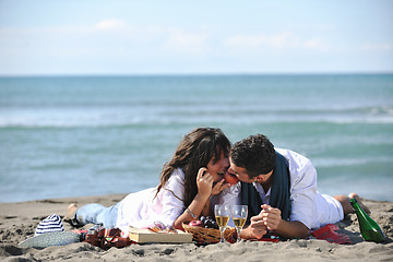 Image showing young couple enjoying  picnic on the beach