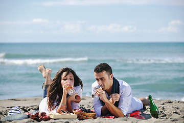 Image showing young couple enjoying  picnic on the beach