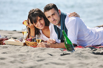 Image showing young couple enjoying  picnic on the beach