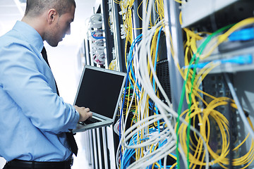 Image showing businessman with laptop in network server room