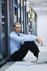 Image showing businessman with laptop in network server room