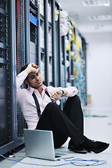 Image showing businessman with laptop in network server room