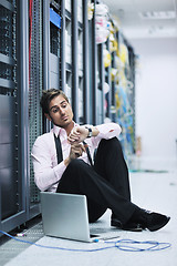 Image showing businessman with laptop in network server room