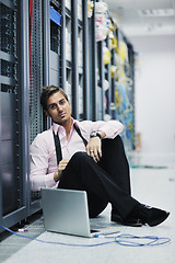 Image showing businessman with laptop in network server room