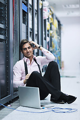 Image showing businessman with laptop in network server room