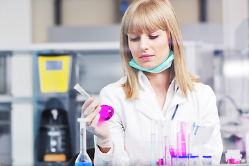 Image showing female researcher holding up a test tube in lab