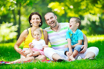 Image showing happy young couple with their children have fun at park