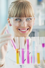 Image showing female researcher holding up a test tube in lab