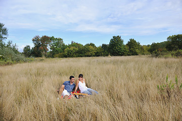 Image showing happy couple enjoying countryside picnic in long grass