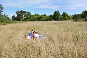 Image showing happy couple enjoying countryside picnic in long grass