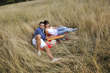 Image showing happy couple enjoying countryside picnic in long grass