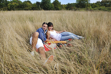 Image showing happy couple enjoying countryside picnic in long grass