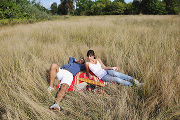 Image showing happy couple enjoying countryside picnic in long grass