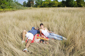 Image showing happy couple enjoying countryside picnic in long grass