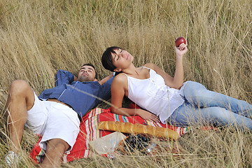 Image showing happy couple enjoying countryside picnic in long grass