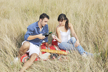 Image showing happy couple enjoying countryside picnic in long grass