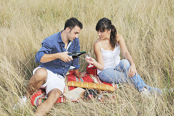 Image showing happy couple enjoying countryside picnic in long grass