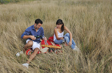 Image showing happy couple enjoying countryside picnic in long grass