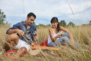 Image showing happy couple enjoying countryside picnic in long grass